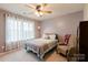 Cozy bedroom featuring a large window, ceiling fan, comfortable chair, and stylish decor at 8828 Powder Works Dr, Huntersville, NC 28078