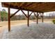 Spacious covered patio features exposed wood beams and a stone tile floor overlooking the backyard at 8828 Powder Works Dr, Huntersville, NC 28078