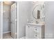 Bright bathroom featuring a vanity with granite countertop and a round mirror at 9035 J M Keynes Dr # 33, Charlotte, NC 28262