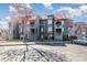 Three-story condo building with red roof, gray siding, round architectural features, and reserved parking spaces at 9035 J M Keynes Dr # 33, Charlotte, NC 28262