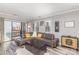 Bright living room featuring a gray leather sectional, wooden floors, and sliding glass doors to a balcony at 9035 J M Keynes Dr # 33, Charlotte, NC 28262