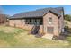 Backyard with a staircase leading to an enclosed patio with a brick exterior and green lawn at 944 Clear Creek Cir, Lincolnton, NC 28092