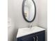 Stylish half bathroom with a modern vanity, oval mirror, and neutral walls at 10430 Alexander Martin Ave, Charlotte, NC 28277