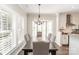 Elegant dining room boasts a large table, stylish chandelier, and bright bay window at 10430 Alexander Martin Ave, Charlotte, NC 28277