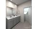 Modern bathroom featuring double sinks, grey cabinets, and a large mirror at 105 Ciara Pl # E, Mooresville, NC 28117