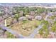 Expansive aerial shot showcasing the brick home's large lot surrounded by lush trees and well-manicured lawns at 105 Partridge Bluff Ne Dr, Concord, NC 28025