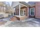 Charming brick home featuring a covered back patio with a columned roof and multi-tiered brick stairs at 105 Partridge Bluff Ne Dr, Concord, NC 28025