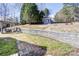 Landscaped backyard featuring a decorative retaining wall, tool shed, pergola, and brick-paved patio at 105 Partridge Bluff Ne Dr, Concord, NC 28025