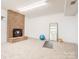 Spacious basement with a brick fireplace, carpet flooring, and ample natural light, ideal for customization at 105 Partridge Bluff Ne Dr, Concord, NC 28025