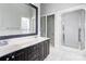 Bathroom featuring a double vanity with dark cabinets, and a walk-in shower with a glass enclosure at 105 Partridge Bluff Ne Dr, Concord, NC 28025