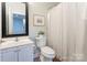 Traditional bathroom features white vanity, decorative mirror, and a charming striped shower curtain at 105 Partridge Bluff Ne Dr, Concord, NC 28025