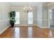 Light-filled dining room featuring hardwood floors, a classic chandelier, and large windows at 105 Partridge Bluff Ne Dr, Concord, NC 28025
