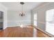 Elegant dining room with hardwood floors, chandelier, crown molding and natural light from large windows at 105 Partridge Bluff Ne Dr, Concord, NC 28025