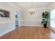 Open dining room with hardwood floors, a chandelier, and view to the kitchen at 105 Partridge Bluff Ne Dr, Concord, NC 28025