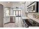 Updated kitchen featuring stainless steel appliances, white cabinets, tile backsplash, and quartz countertops at 105 Partridge Bluff Ne Dr, Concord, NC 28025