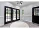 Inviting sunroom with black grid doors, ample natural light, and tile flooring, creating a cozy transitional space at 105 Partridge Bluff Ne Dr, Concord, NC 28025