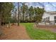 Well-maintained backyard featuring green grass, pine straw, and wooden porch with black metal railing at 121 Yorkshire Dr, Salisbury, NC 28144