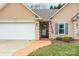Welcoming front entrance with a decorative door, American flag, green shutters, and manicured landscaping at 121 Yorkshire Dr, Salisbury, NC 28144
