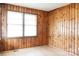Cozy bedroom featuring wood-paneled walls, laminate flooring, and natural light from the window at 1606 Mt Gallant Rd, Rock Hill, SC 29732