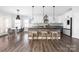 Modern kitchen with white cabinets, stainless steel appliances, an island and pendant lighting at 16115 Chiltern Ln, Huntersville, NC 28078