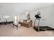 Inviting living space with a comfortable sofa, treadmill, and built-in shelves for storage and display at 16115 Chiltern Ln, Huntersville, NC 28078