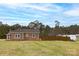 Expansive backyard with well-maintained lawn and brick ranch-style home surrounded by mature trees at 2005 Douglas Rd, Lancaster, SC 28720