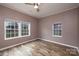 This bedroom features two large windows, wood floors, fresh paint, and a ceiling fan at 2005 Douglas Rd, Lancaster, SC 28720