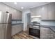 This kitchen features stainless steel appliances and grey cabinets for style and functionality at 2005 Douglas Rd, Lancaster, SC 28720