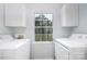 Convenient laundry room featuring side-by-side washer and dryer, as well as built in shelving and a window at 2005 Douglas Rd, Lancaster, SC 28720
