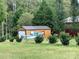 Outbuilding exterior with wood siding, metal roof, and a boat parked outside at 211 Honeycutt Rd, Troutman, NC 28166