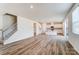 Spacious living room featuring wood-look flooring, stairs, and a view into the kitchen at 2639 Tillman St, Monroe, NC 28112