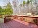Inviting red-stained deck with a railing offering views of the lush backyard and surrounding trees at 314 Sugar Creek Xing, Fort Mill, SC 29715