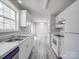 Bright kitchen featuring white cabinets, stainless steel sink, and views into the dining area with sliding doors at 314 Sugar Creek Xing, Fort Mill, SC 29715