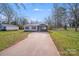 Charming single-story home with a large driveway, cozy porch, and well-maintained lawn at 327 Berry St, Rock Hill, SC 29732