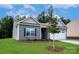 Charming single-story home with gray siding, stone accents, well-manicured lawn, and an attached two-car garage at 3512 Narrow Ln, Charlotte, NC 28215