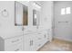 Bathroom with dual sinks, white cabinets, and large mirrors at 4227 Holly Ne Cir, Conover, NC 28613