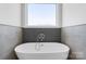 Modern bathroom featuring a luxurious standalone tub with designer faucet and tiled wall feature at 4227 Holly Ne Cir, Conover, NC 28613