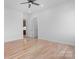 Bedroom features hardwood floors, white walls, ceiling fan, and a view to a hallway and kitchen at 4227 Holly Ne Cir, Conover, NC 28613