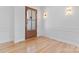 Elegant foyer with hardwood floors, white walls, modern lighting and a wood front door at 4227 Holly Ne Cir, Conover, NC 28613