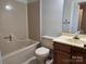 Cozy bathroom featuring tub-shower combo, toilet, and vanity with dark wood cabinets at 446 Windsor Ln, Statesville, NC 28677
