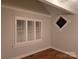 Bedroom view showcasing hardwood floors, window shutters, and decorative stained glass at 446 Windsor Ln, Statesville, NC 28677