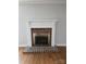 Close-up of a fireplace with decorative white mantle and brick surround in the living room at 446 Windsor Ln, Statesville, NC 28677
