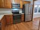 Kitchen with stainless steel appliances, oak cabinets, and hardwood floors at 446 Windsor Ln, Statesville, NC 28677