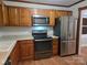 Modern kitchen with stainless steel appliances, wooden cabinets, and hardwood floors at 446 Windsor Ln, Statesville, NC 28677