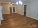 Open living room with hardwood floors, brick fireplace, and glass doors leading to the outside at 446 Windsor Ln, Statesville, NC 28677