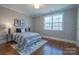 Bedroom with a large window, hardwood floors, neutral paint, and minimalist decor at 447 Beacon Nw St, Concord, NC 28027