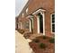 Brick townhomes showcasing black doors with white frames, brick steps, and landscaped yards at 447 Beacon Nw St, Concord, NC 28027