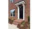 Charming brick house showcasing a black front door with a white frame, brick steps, and meticulous landscaping at 447 Beacon Nw St, Concord, NC 28027