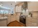 Bright kitchen featuring white cabinetry, stainless steel appliances, and granite countertops at 447 Beacon Nw St, Concord, NC 28027