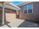 Brick patio with white support beams, a covered area, and a view of the brick wall and window at 447 Beacon Nw St, Concord, NC 28027
